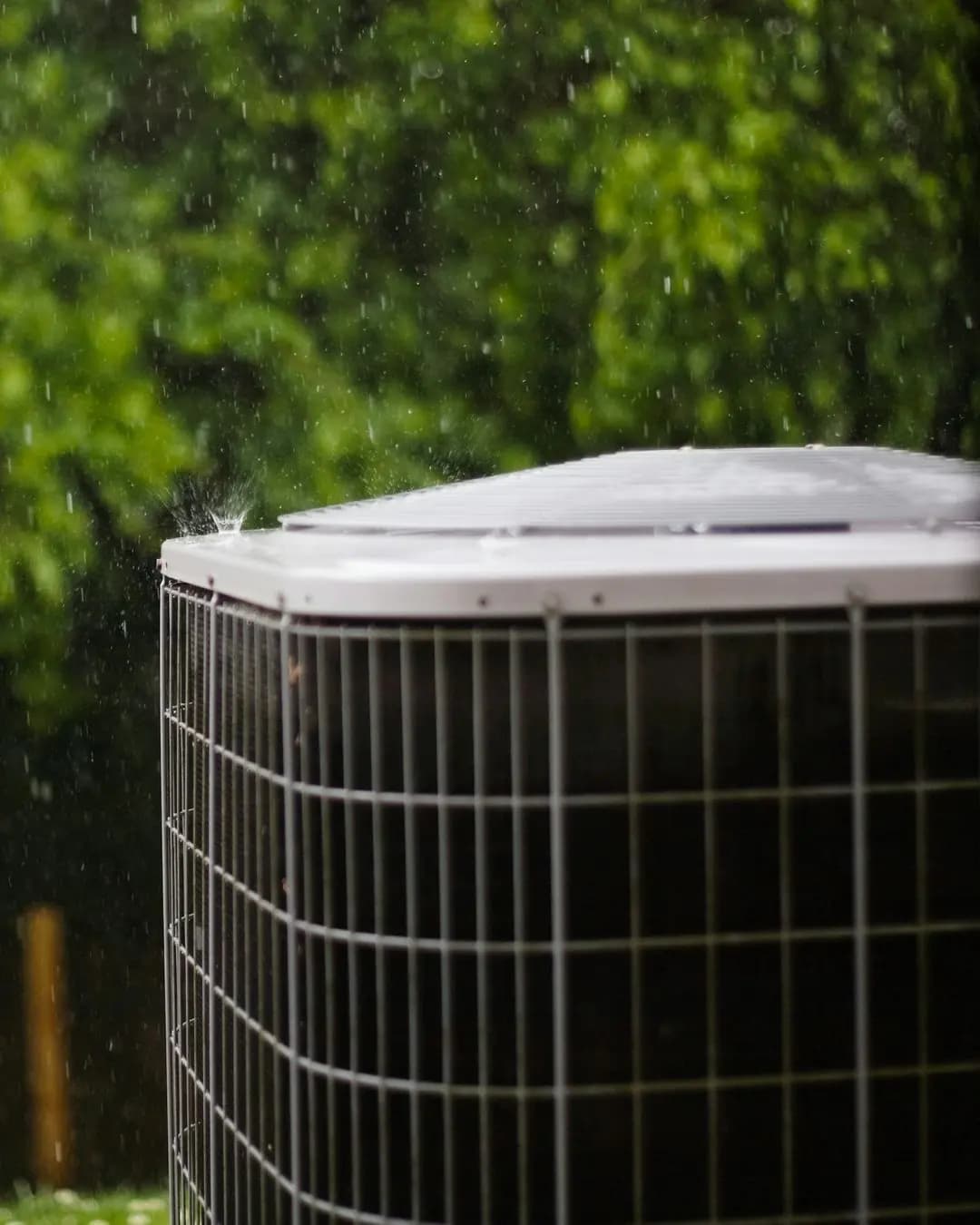 Central air conditioner outside a house in the rain